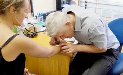 Dr Gavin Lobo examining a patient's mole during a skin check